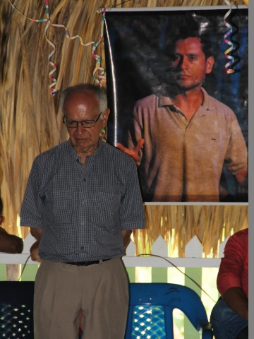 Der Jesuitenpater Javier Giraldo, der die Friedensgemeinde seit ihrer Gründung begleitet vor dem Bild des verstorbenen Anführers Eduar Lanchero. Der Pater erinnert an der Feier an die vielen ermordeten Mitglieder der Gemeinde.