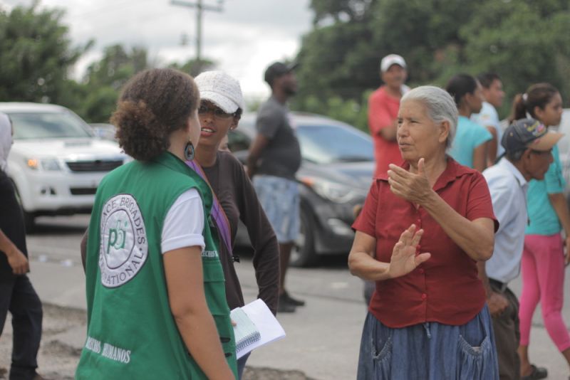 Jeannine K. en conversation avec des personnes touchées par un mégaprojet.